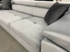 Nahaufnahme der grauen Stoffstruktur eines Sofas mit schwarzen Zierkissen.