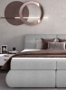 Modernes graues Boxspringbett mit braunen Kissen in einem stilvoll eingerichteten Schlafzimmer.