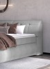 Seitenansicht des weich gepolsterten grauen Kopfteils eines modernen Boxspringbettes.