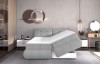 Graues Boxspringbett mit offenem Bettkasten zur Lagerung von Bettzeug im Schlafzimmer.