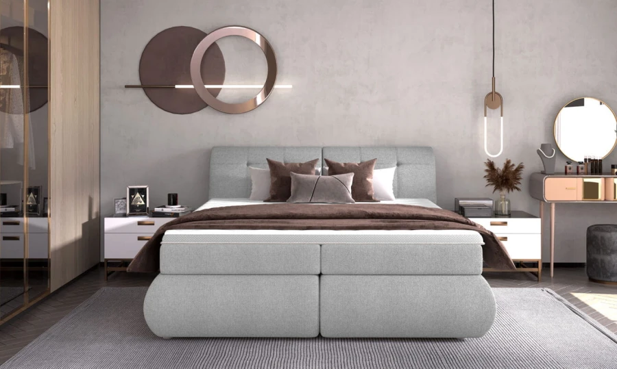 Graues Boxspringbett mit gepolstertem Kopfteil in modernem Schlafzimmer-Interieur.