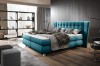 Türkises Boxspringbett mit hohem, gestepptem Kopfteil im modernen Loft-Stil.