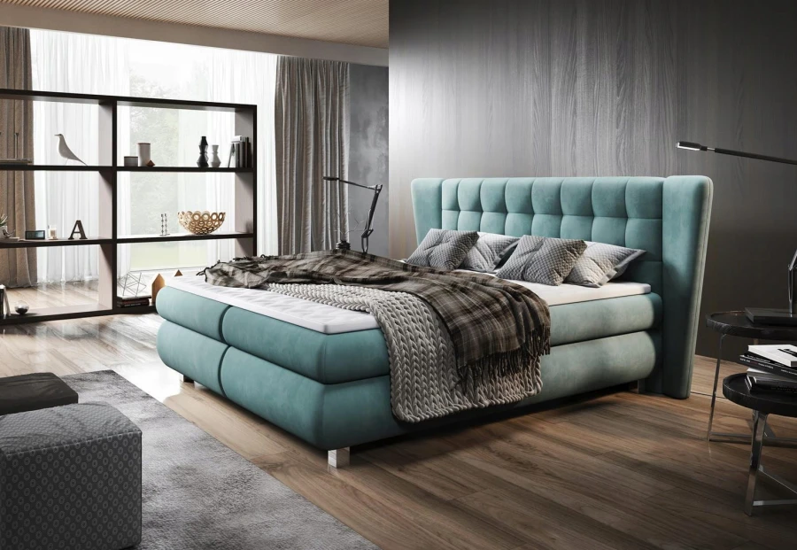 Mintgrünes Boxspringbett mit gestepptem Kopfteil in hellem, modernen Schlafzimmer.
