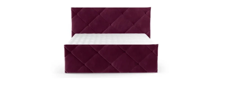 Weinrotes Boxspringbett mit samtigem Bezug und geometrischer Steppung vor weißem Hintergrund.