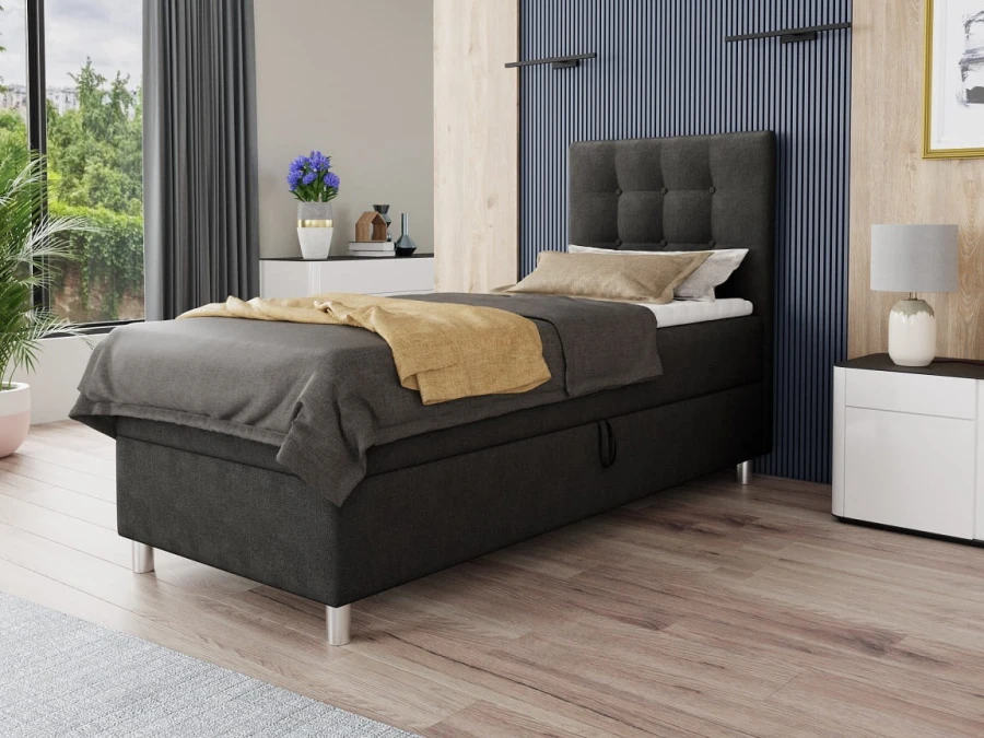 Modernes Polsterbett in Anthrazit mit gestepptem Kopfteil in einem hellen Schlafzimmer.