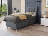 Modernes graues Boxspringbett im Schlafzimmer mit gestepptem Kopfteil.
