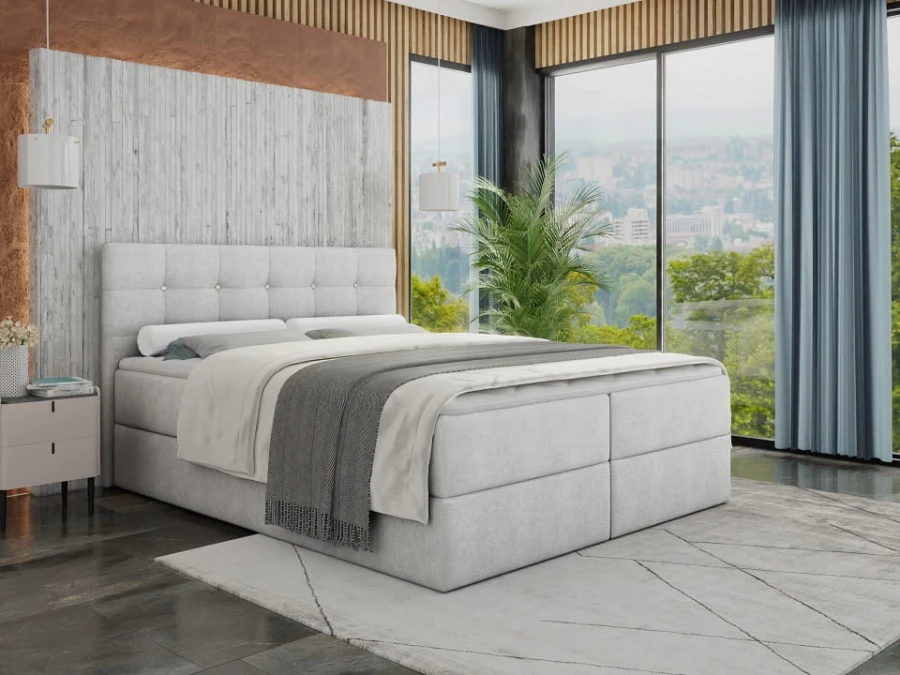Gemütliches graues Boxspringbett in einem modernen Schlafzimmer mit Panoramafenster.