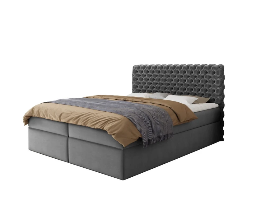 Graues Boxspringbett aus Samt mit gestepptem Kopfteil auf weißem Hintergrund.