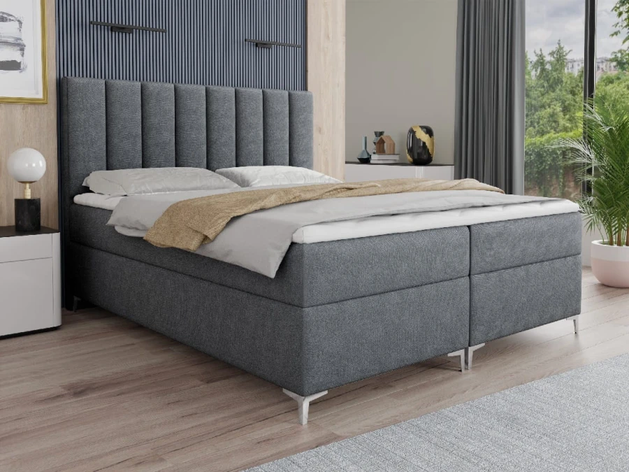 Graues Boxspringbett mit modernem Design und gestepptem Kopfteil.