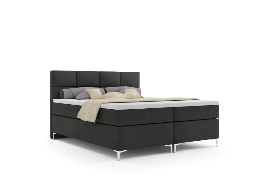 Dunkelgraues Boxspringbett mit gepolstertem Kopfteil auf weißem Grund