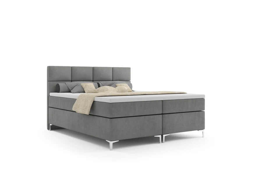 Graues Boxspringbett mit elegantem Kopfteil und silbernen Füßen auf weißem Hintergrund.