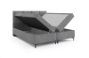 Graues Boxspringbett mit weit geöffneten Bettkästen für praktischen Stauraum im Schlafzimmer.
