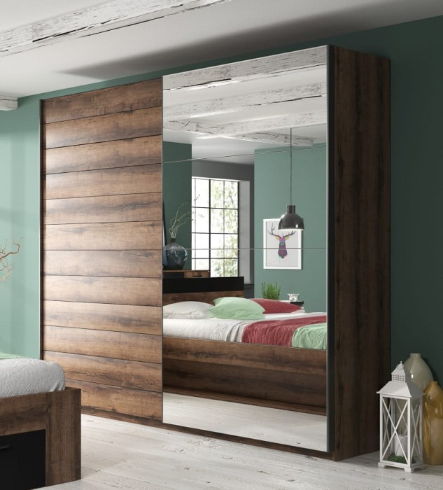 Schwebetürenschrank mit Holzdekor und Spiegel in einem stilvoll eingerichteten Schlafzimmer.
