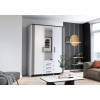 Stilvoller weißer Schrank mit Spiegel und Lamellen-Design in einem modernen Wohnbereich.