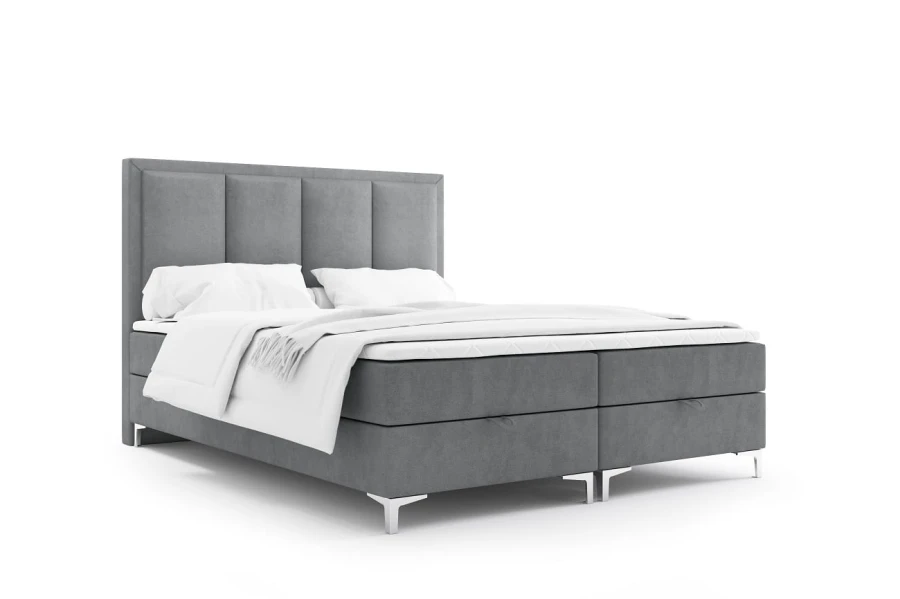 Graues Boxspringbett mit gepolstertem Kopfteil und weißer Bettwäsche auf weißem Hintergrund.