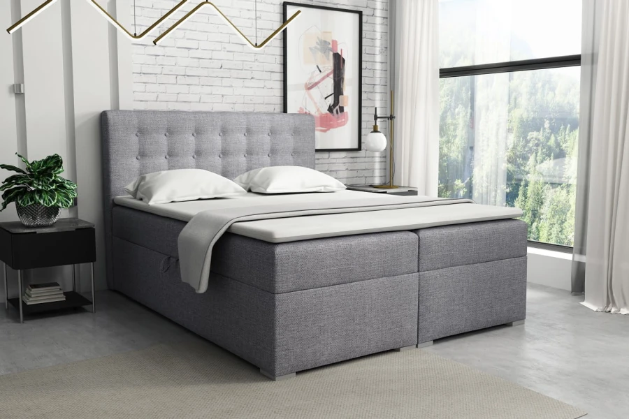 Hellgraues Boxspringbett aus Strukturstoff mit Knopfsteppung in modernem Schlafzimmer-Ambiente.