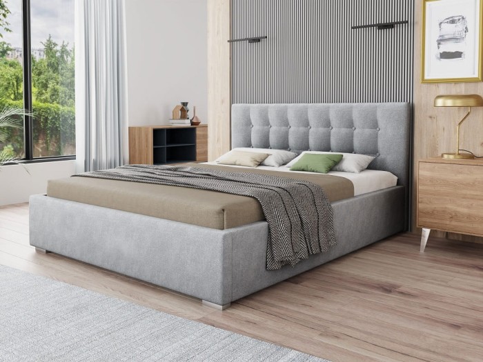 Modernes Schlafzimmer mit grauem Polsterbett, gestepptem Kopfteil und gemütlicher Deko.