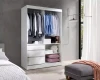Offener weißer Kleiderschrank mit Kleiderstangen und Schubladen im modernen Schlafzimmer.