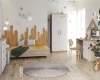 Helles Kinderzimmer mit Holzbett in Skyline-Optik, weißem Kleiderschrank und Schreibtisch.