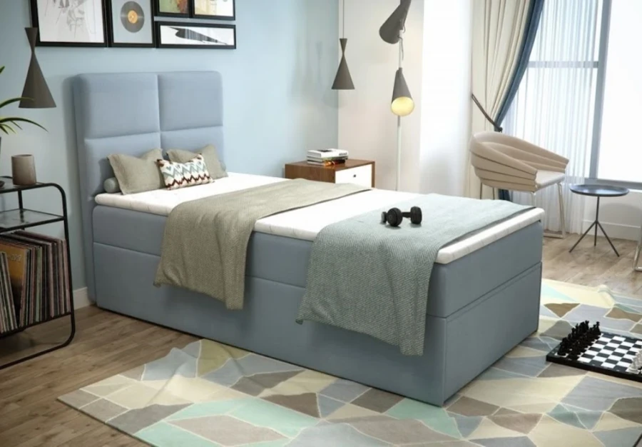 Hellblaues Boxspringbett für Singles mit gepolstertem Kopfteil in einem modernen Jugendzimmer.