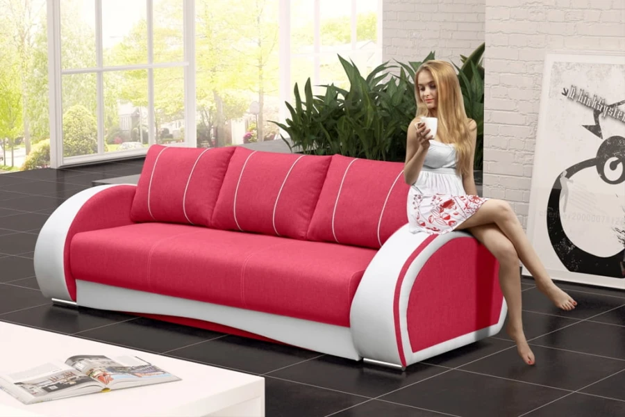 Pink-weißes Designer-Sofa im hellen Wohnzimmer mit Frau auf der Armlehne.
