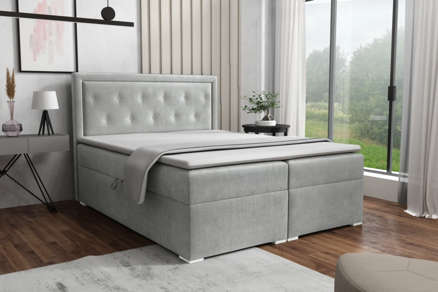 Hellgraues Boxspringbett mit abgestepptem Kopfteil in modernem Schlafzimmer.
