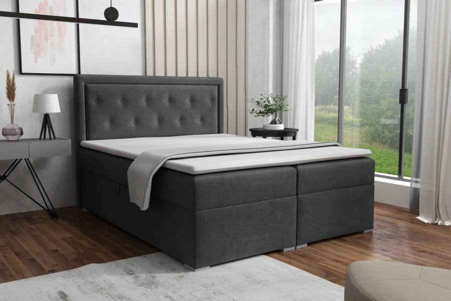 Dunkelgraues Boxspringbett im Schlafzimmer-Ambiente mit großem Fenster.