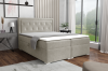 Beiges Boxspringbett mit Stauraumfunktion in heller Schlafzimmerumgebung.
