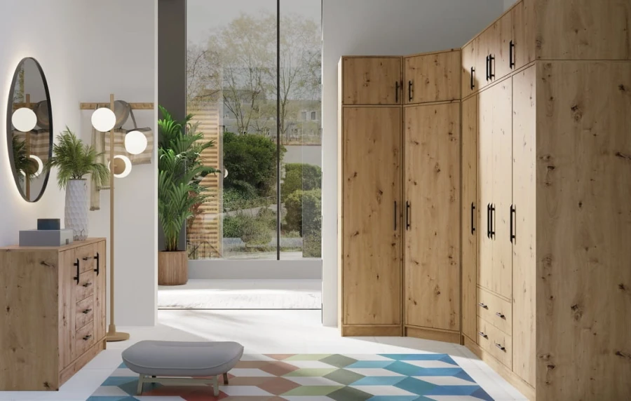 Eckkleiderschrank und Kommode in Eiche-Optik mit schwarzen Griffen im Schlafzimmer.