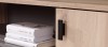 Detail eines schwarzen Türgriffs an einem modernen Holzschrank mit Regalen.