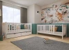 Modernes Kinderzimmer mit zwei weißen Holzbetten und Wandbild mit australischen Tieren.