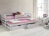 Weißes Kinderbett aus Massivholz mit Gästebett und Schubladen in einem hellen Mädchenzimmer.