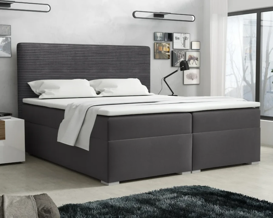 Dunkelgraues Boxspringbett mit strukturiertem Kopfteil in einem modernen Schlafzimmer.