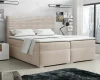 Beiges Boxspringbett mit elegantem Cord-Kopfteil in einem stilvoll eingerichteten Schlafzimmer.