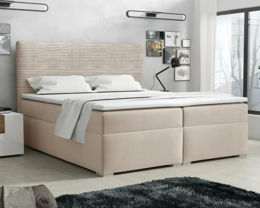Beiges Boxspringbett mit elegantem Cord-Kopfteil in einem stilvoll eingerichteten Schlafzimmer.