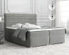 Graues Boxspringbett mit gestepptem Kopfteil in einem hellen Schlafzimmer