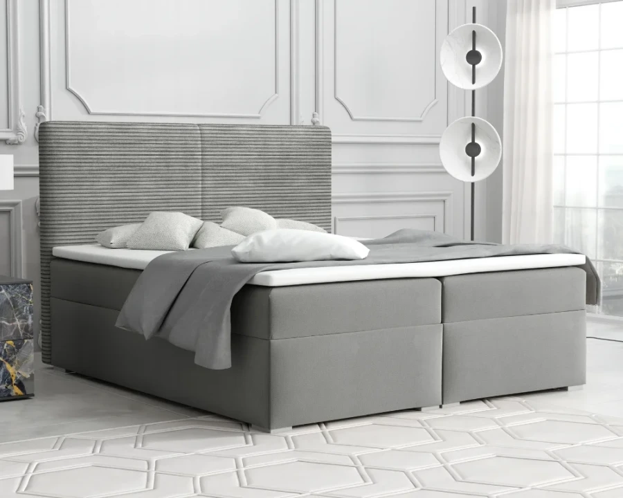 Graues Boxspringbett mit gestepptem Kopfteil in einem hellen Schlafzimmer