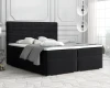 Elegantes schwarzes Boxspringbett mit Polster-Kopfteil in luxuriösem Ambiente.