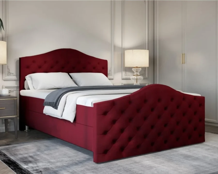 Elegantes weinrotes Boxspringbett mit Knopfsteppung an Kopf- und Fußteil im klassischen Schlafzimmer.
