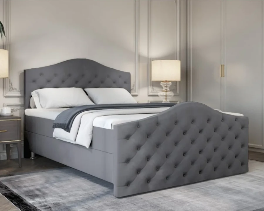 Luxuriöses Boxspringbett in Grau mit eleganter Knopfheftung an Kopf- und Fußteil im Schlafzimmer.