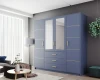 Moderner blauer Kleiderschrank mit Spiegeltüren und goldenen Griffen im Wohnzimmer-Ambiente.