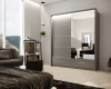 Großer grauer Kleiderschrank mit Spiegelfront in einem hellen, modern eingerichteten Schlafzimmer.