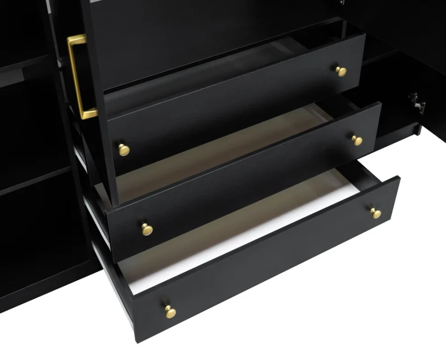 Detailaufnahme von drei schwarzen Schubladen mit eleganten goldenen Knöpfen