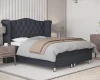 Seitenansicht eines gemütlichen grauen Boxspringbetts in einem stilvoll eingerichteten Schlafzimmer.