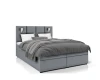 Graues Boxspringbett mit gepolstertem Kopfteil und Leselampen auf weißem Hintergrund.