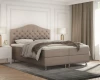 Moderner Schlafzimmer-Look mit beigem Polsterbett und Metallfüßen.