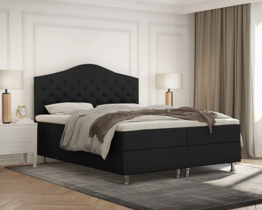 Schwarzes Boxspringbett mit hohem, gestepptem Kopfteil.