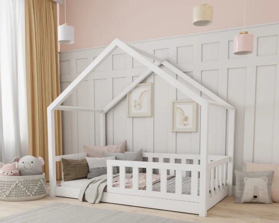 Weißes Kinder-Hausbett aus Holz mit Rausfallschutz und dekorativen Kissen im modernen Kinderzimmer.