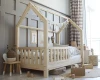 Skandinavisches Kinderbett in Hausform aus Massivholz mit heller Dekoration.
