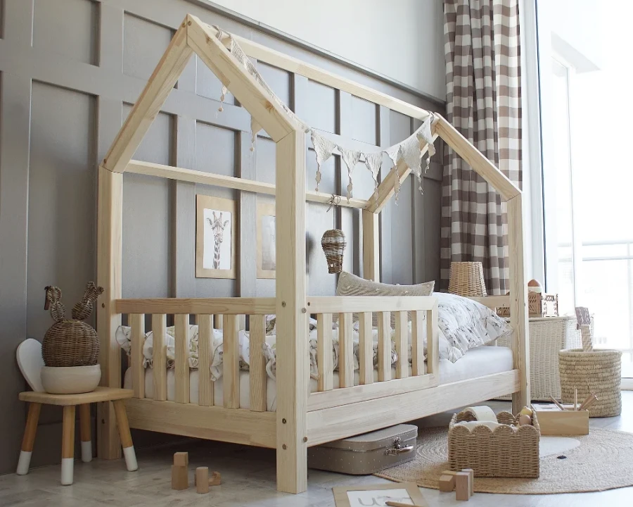 Skandinavisches Kinderbett in Hausform aus Massivholz mit heller Dekoration.